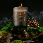 Candle with a label on a decorative stand with greenery and smoke effect