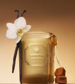 Aromatica Warm Vanilla candle with vanilla bean and orchid on a warm background